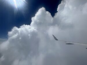 Wolke mit Flugzeugflügel und Sonne